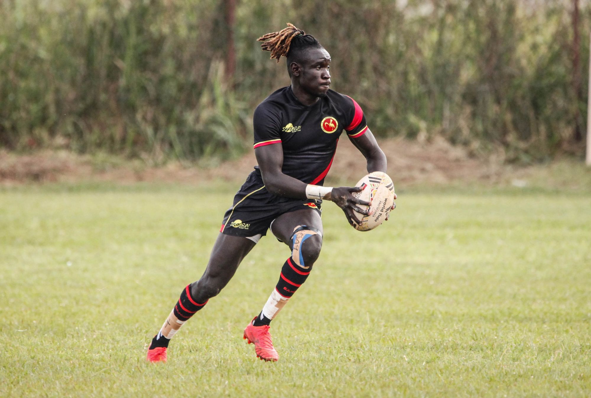 Joueur de rugby lancé, balle en main, traité en noir et blanc contrasté